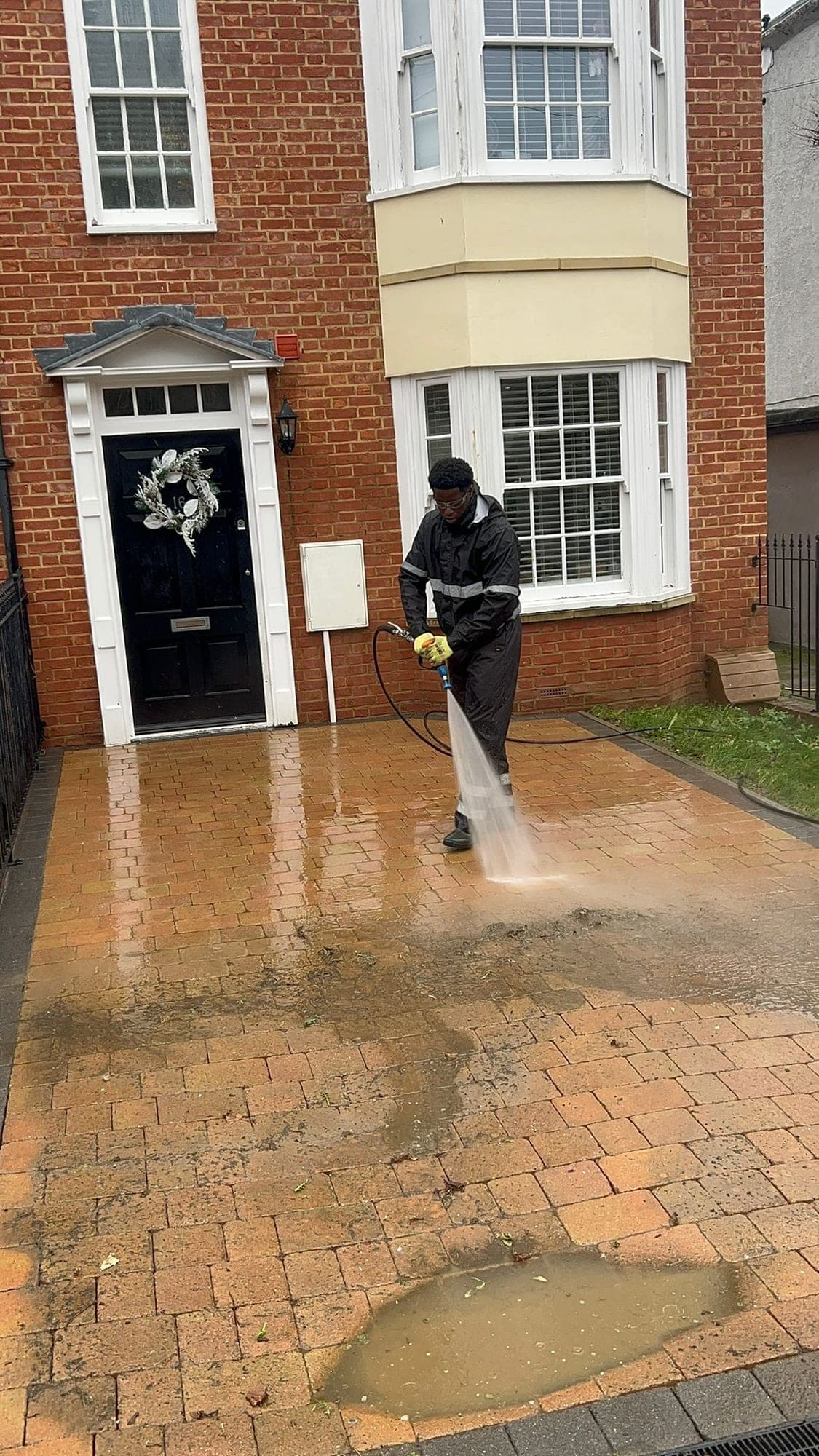 Pushing Pressure team member pressure washing a block paved driveway